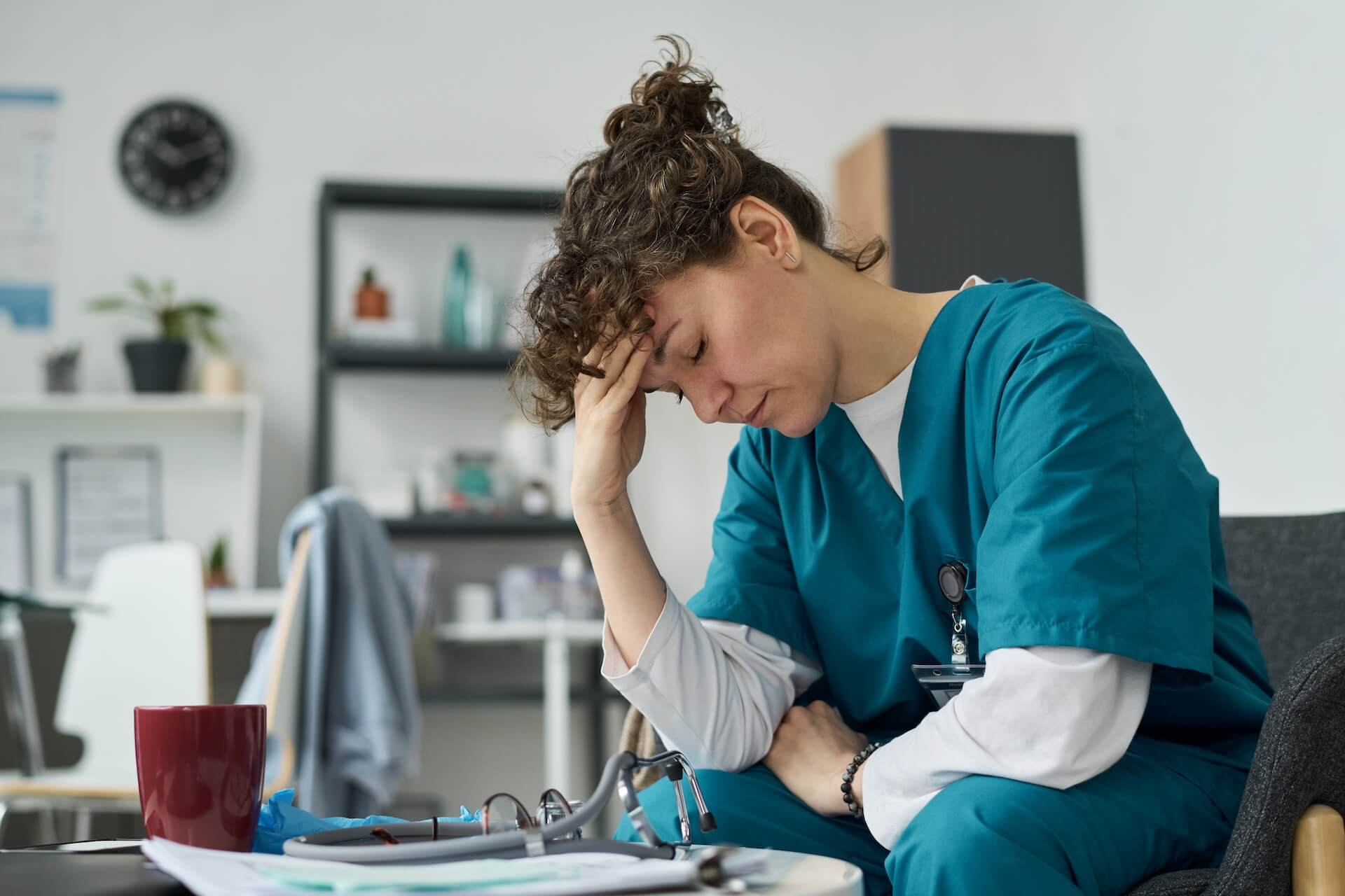 tired woman healthcare worker sitting down at work